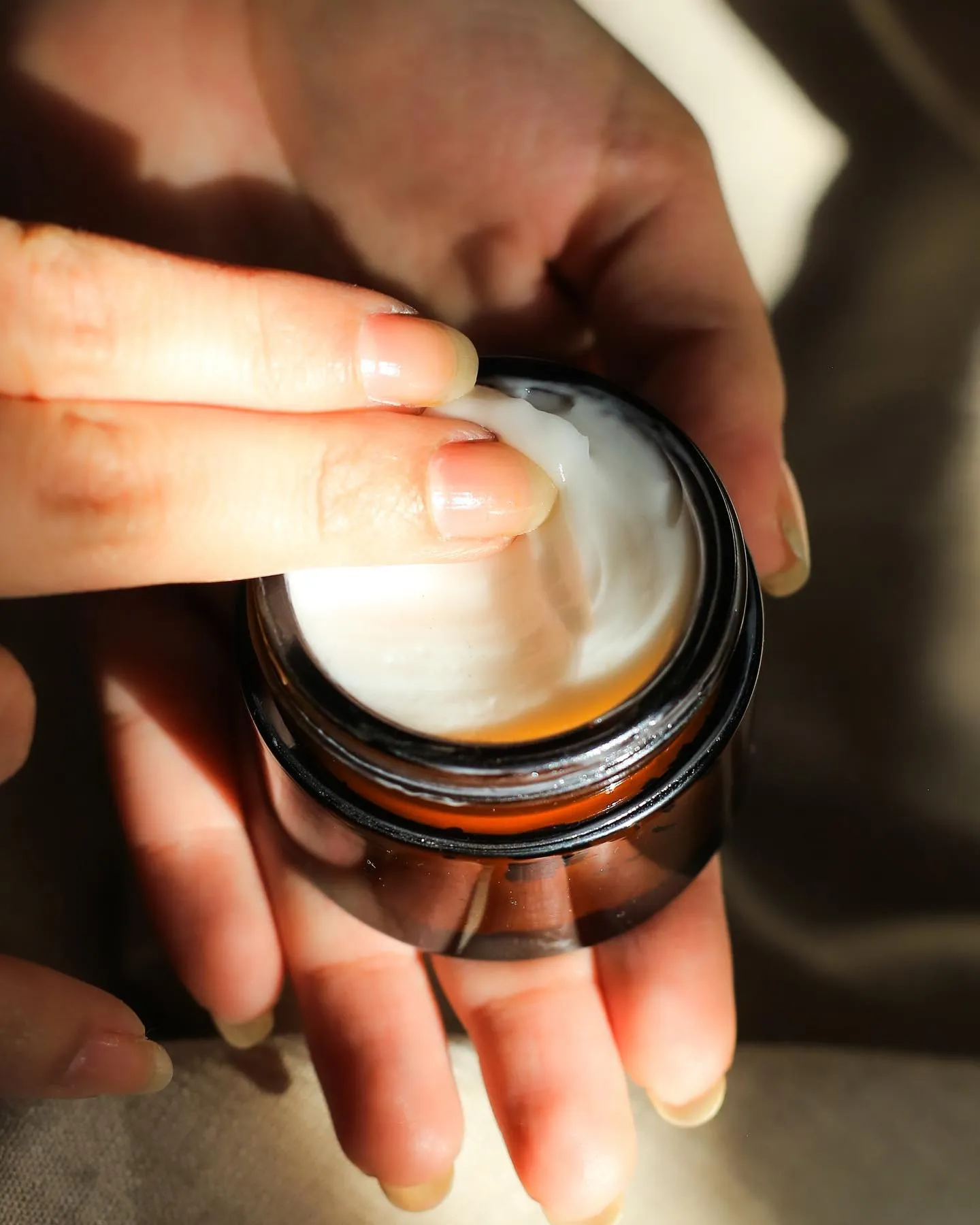 Primer plano de la textura de la crema facial Seidh aplicándose sobre la mano